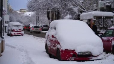 Sabahları arabalarda kar yağar. Romanya 'nın Bükreş kentinde sabah trafiğinde kış mevsimi ve buzlu arabalar yolda.