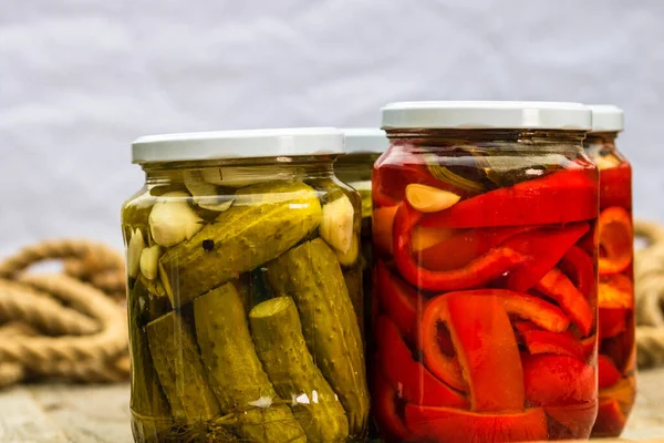 赤ピーマンを漬けガラス瓶とキュウリ 孤立した 酢漬け野菜の様々な瓶 素朴な構成で保存食の概念 — ストック写真