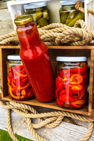 Skrzynia Drewniana Butelkami Sosem Pomidorowym Szklanymi Słoikami Marynowaną Czerwoną Papryką — Zdjęcie stockowe
