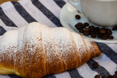 Puf böreği, kahve fincanı ve ahşap sandıkta tereyağlı Fransız kruvasanı. Yemek ve kahvaltı konsepti. Kahve tatlısı ve taze hamur işlerinin detayları.