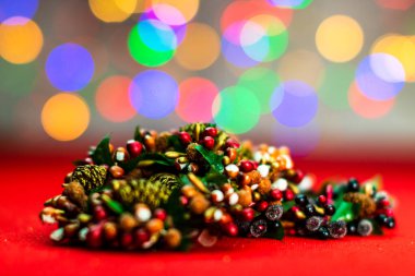 Bulanık ışıkların arka planında izole edilmiş renkli Noel çelenkleri.