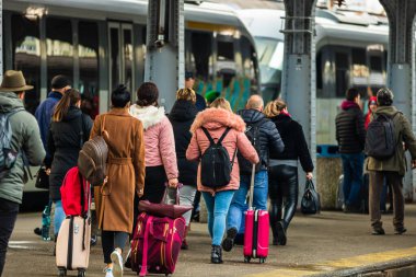 Romanya 'nın Bükreş kentindeki Bükreş Kuzey Demiryolu İstasyonu' nun (Gara de Nord Bükreş) tren peronunda bavul ve sırt çantası taşıyan gezginler ve banliyö yolcuları görülüyor.