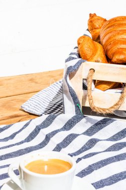 Puf böreği, kahve fincanı ve ahşap sandıkta tereyağlı Fransız kruvasanı. Yemek ve kahvaltı konsepti. Kahve tatlısı ve taze hamur işlerinin detayları.