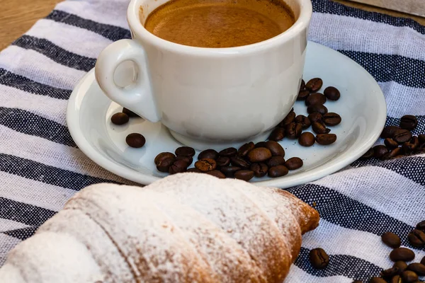 咖啡杯和涂了黄油的法国羊角面包放在木板箱上 食品和早餐的概念 咖啡甜点和新鲜糕点的细节 — 图库照片