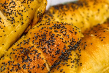 Hamurun içine tuz ve haşhaş tohumu serpiştirilmiş sosislerin detaylarını yakından incele. Sosisli börek, lezzetli ev yapımı hamur işleri..