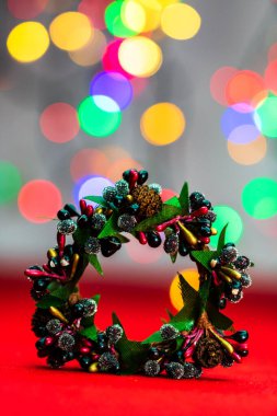 Bulanık ışıkların arka planında izole edilmiş renkli Noel çelenkleri.