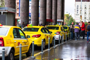 Trafikte araba, modern şehir taksi servisi. Romanya 'nın başkenti Bükreş' teki taksi durağına park etmiş taksi arabaları, 2020