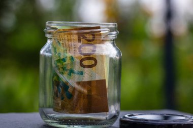 İsviçre frangı CHF banknotu cam kavanozda para biriktiriyor. Tüketim ve ekonomi. İş, bahşiş, finans, tasarruf, bankacılık ve insan kavramı