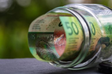 İsviçre frangı CHF banknotu cam kavanozda para biriktiriyor. Tüketim ve ekonomi. İş, bahşiş, finans, tasarruf, bankacılık ve insan kavramı