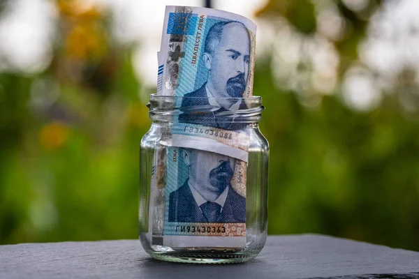 Bulgar LEVA banknotu cam kavanozda para biriktiriyor. Tüketim ve ekonomi. İş, bahşiş, finans, tasarruf, bankacılık ve insan kavramı