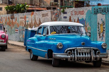 Havana, Küba 'da klasik Amerikan arabası. Renkli binalar ve eski arabalarla tipik Havana şehir manzarası