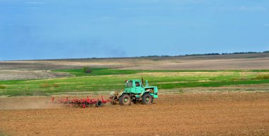 gelecekteki dikim için toprak alanında çalışan traktör pulluklar