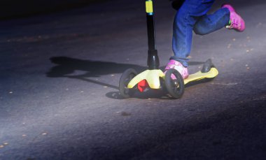 Scooter üzerinde binmek küçük bir çocuk öğrenir gün ışığında tekme