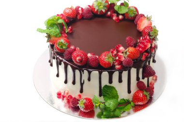 Kek Ahududu çilek nar nane meyveleri ile kaplı izole beyaz arka plan üzerinde çikolata ile doused bırakır