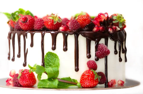 white cake poured with brown chocolate and decorated with berries on an isolated white background