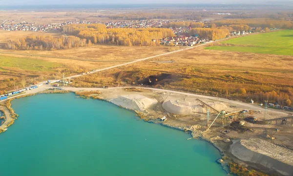bir kum maden ocağı havadan görünümü deftere nakledilen İnşaat ekipmanları ve ekskavatör ile turkuaz bir gölde