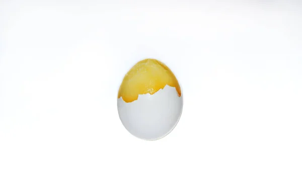 frozen yolk in broken and peeled egg on an isolated white background