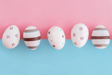 Çizgili ve çiçek pembe ve mavi arka plan, Paskalya kavramı üzerinde yumurta süslenmiş.