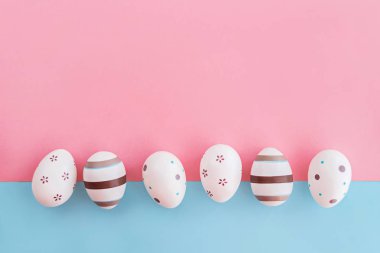 Çizgili ve çiçek pembe ve mavi arka plan, Paskalya kavramı üzerinde yumurta süslenmiş.