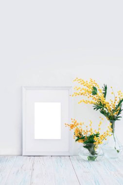 Boş beyaz ahşap çerçeve ve kopya alanı sarı Mimoza çiçeklerle. Mockup.