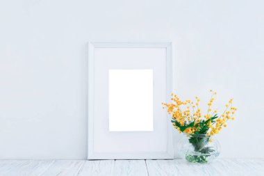 Boş beyaz ahşap çerçeve ve kopya alanı sarı Mimoza çiçeklerle. Mockup.