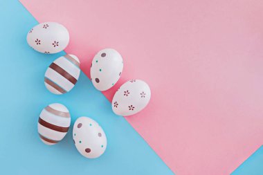 Çizgili ve çiçek pembe ve mavi arka plan, Paskalya kavramı üzerinde yumurta süslenmiş.