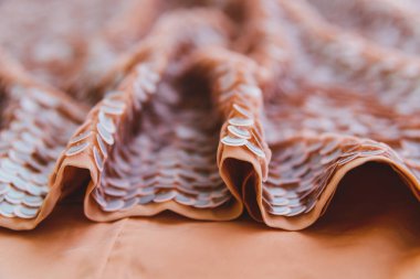 Açık pembe parlak kumaş pullu, soyut arkaplan.