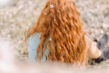 Beyaz çiçekli kıvırcık kızıl saçlı, arka görüş.