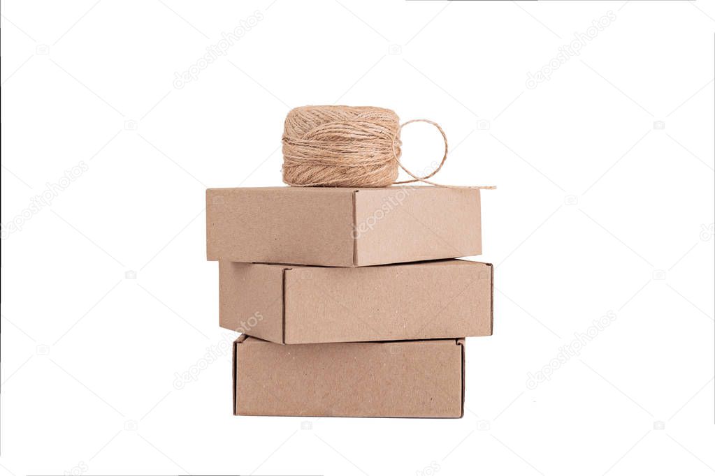 Stack of craft paper boxes and coil of rope isolated on white.