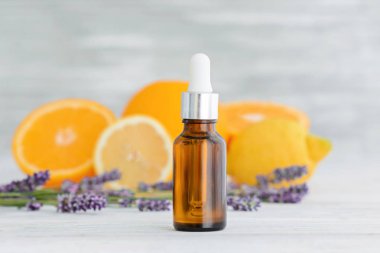 Ahşap arka planda narenciye doğal turuncu, limon ve Lavanta esansiyel yağı ile şişe.