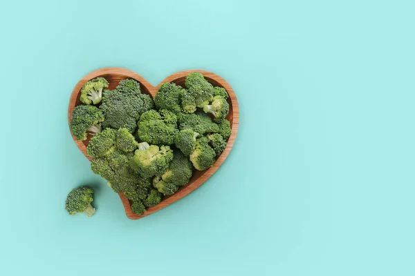 Świeże zielone brokuły w kształcie serca na drewnianej płycie izolowane na białym. — Zdjęcie stockowe