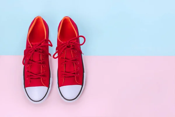 粉红色和蓝色背景的新红色运动鞋，带复印空间. — 图库照片