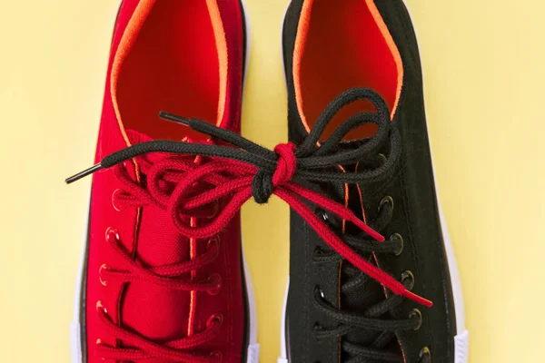 Nya röda och svarta sneakers på gul bakgrund med kopierings utrymme. — Stockfoto