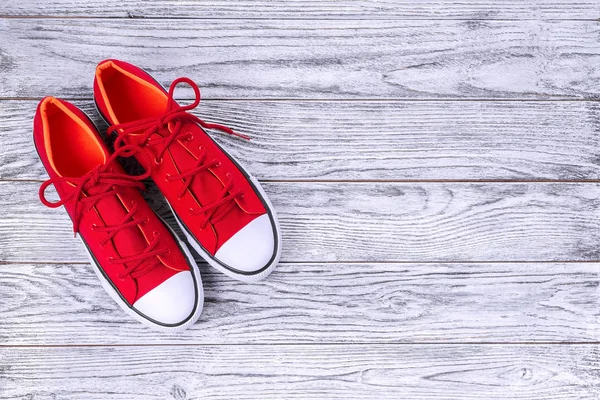 Nya röda sneakers på trä bakgrund med kopierings utrymme. — Stockfoto