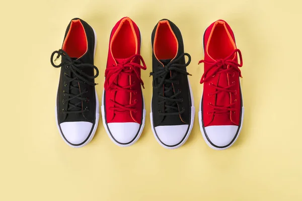 Нові червоні та чорні кросівки на жовтому тлі з копіювальним простором . — стокове фото
