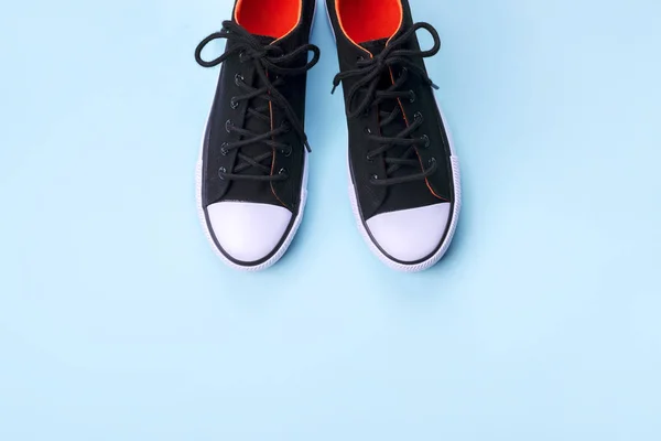 Нові чорні кросівки на блідо-блакитному фоні з копіювальним простором . — стокове фото