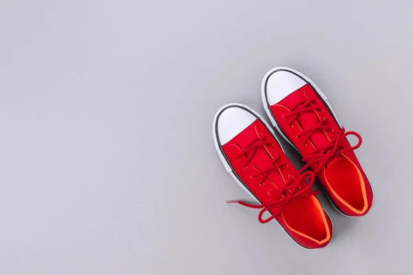Nya röda sneakers på grå bakgrund med kopieringsutrymme. — Stockfoto
