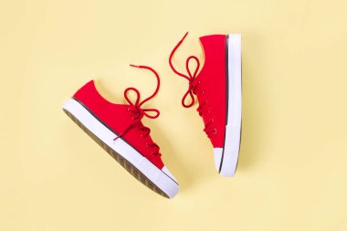 Kopyalama alanı ile sarı arka planda yeni kırmızı spor ayakkabıları.