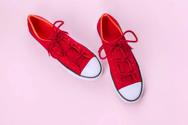 Nya röda sneakers på rosa bakgrund med kopieringsutrymme. — Stockfoto
