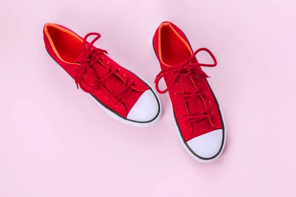 Nouvelles baskets rouges sur fond rose avec espace de copie . — Photo