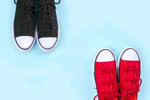 Nya svarta och röda sneakers på ljusblå bakgrund med kopierings utrymme. — Stockfoto