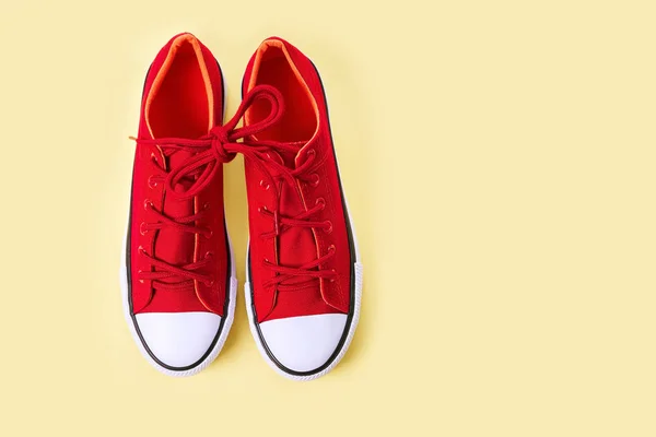 Nouvelles baskets rouges sur fond jaune avec espace de copie . — Photo