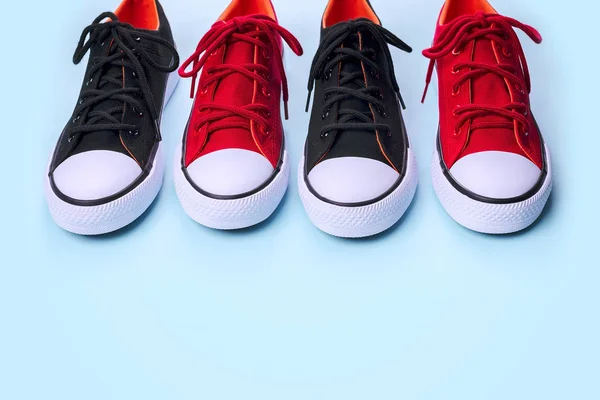 Новые черные и красные кроссовки на бледно-синем фоне с копировальным пространством . — стоковое фото