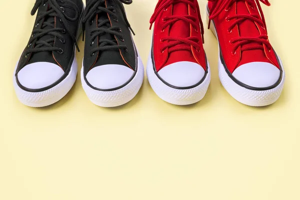 Nya svarta och röda sneakers på gul bakgrund med kopierings utrymme. — Stockfoto