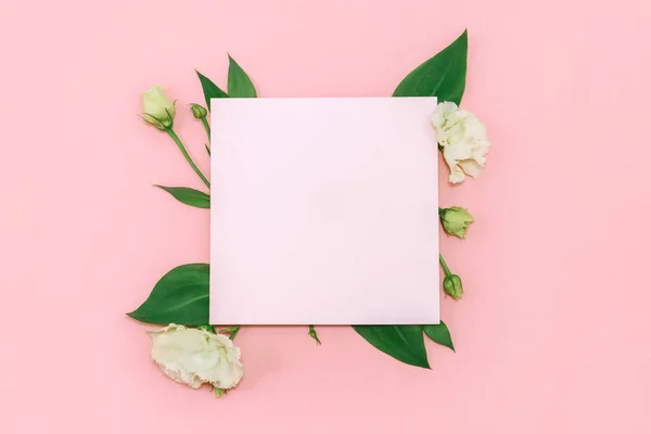 Papier blank mit frischen weißen Blumen auf pastellrosa Hintergrund. flache Lage, Draufsicht. — Stockfoto