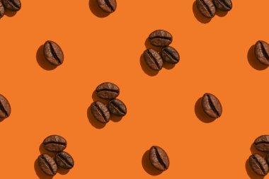 Turuncu arka planda kahve çekirdekleri yaratıcı desen.