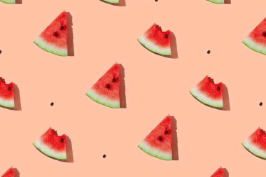 Mercan pembe zemin üzerinde dilimlenmiş karpuzdan yapılmış karpuz deseni.