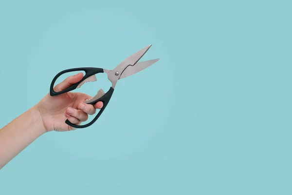 Tijeras de mano de mujer sobre fondo azul con espacio para copiar . —  Fotos de Stock