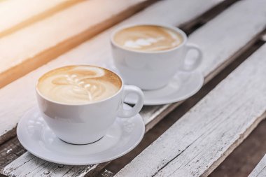 Beyaz ahşap masanın üzerinde, fotokopi alanı olan iki büyük fincan kahve..