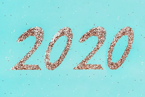Brillos dorados en forma de 2020 sobre fondo de menta verde . —  Fotos de Stock